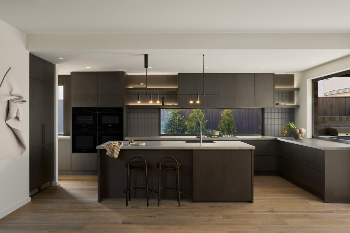 Luxury kitchen Brisbane with dark bespoke cabinetry, central island, pendant lights, and natural light from large windows.